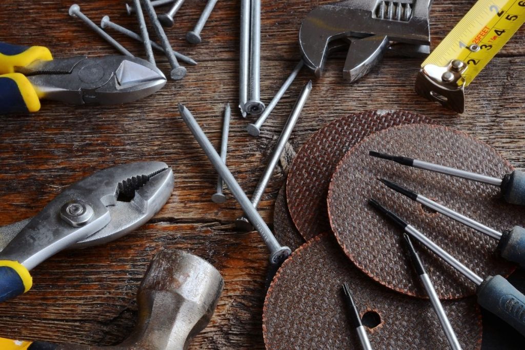 A wooden table displaying various tools, including a ruler and pliers, arranged neatly for easy access.