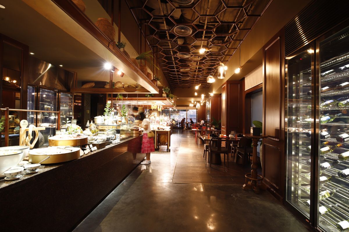  A restaurant interior featuring a long counter and a refrigerator, creating a welcoming dining atmosphere.